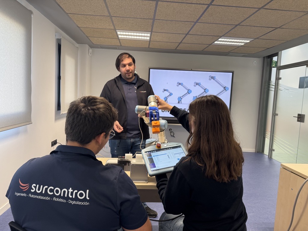 Alumnos manejando un robot colaborativo Universal Robots con su consola