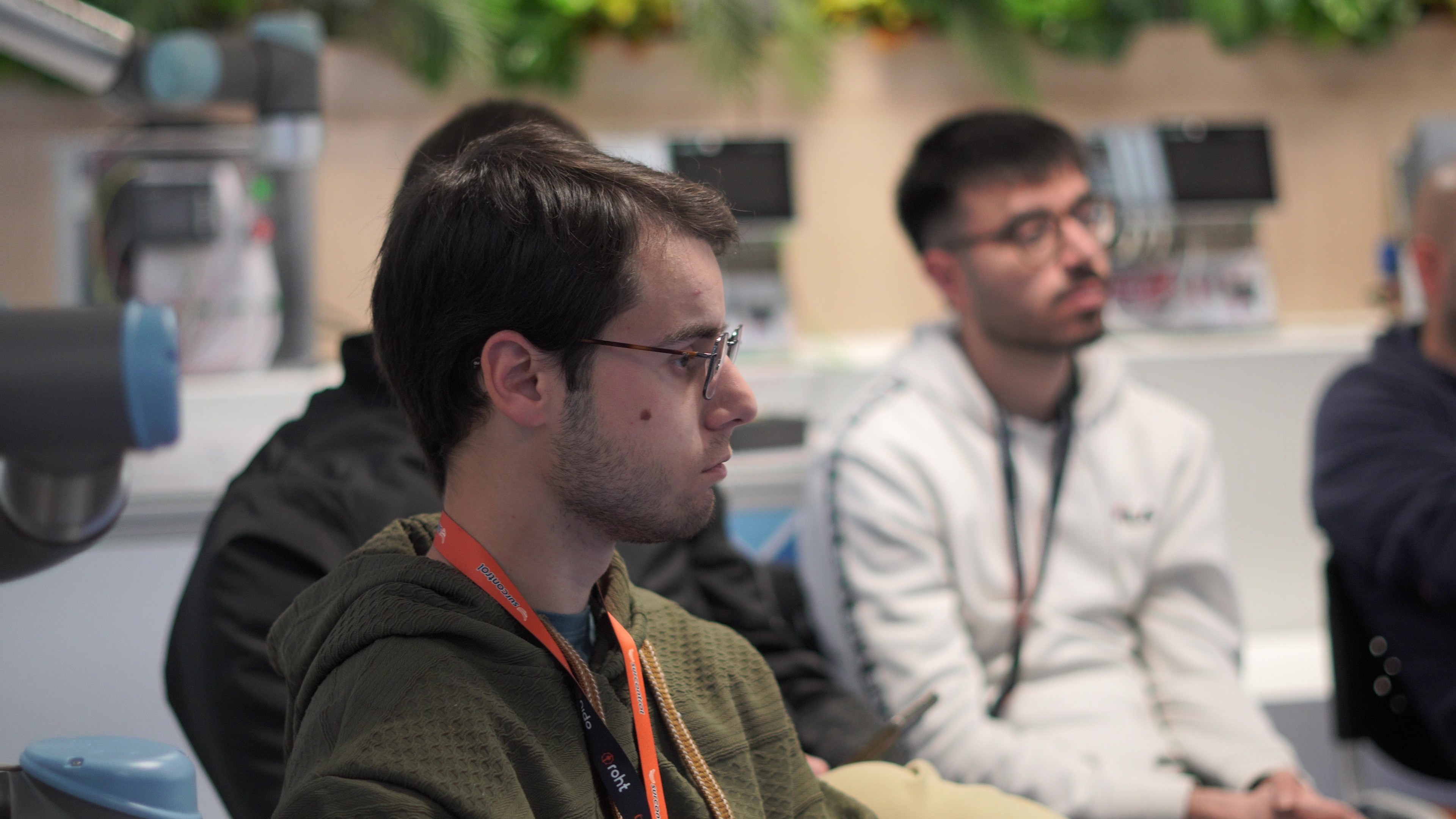 Alumnos siguiendo una clase junto a un robot colaborativo